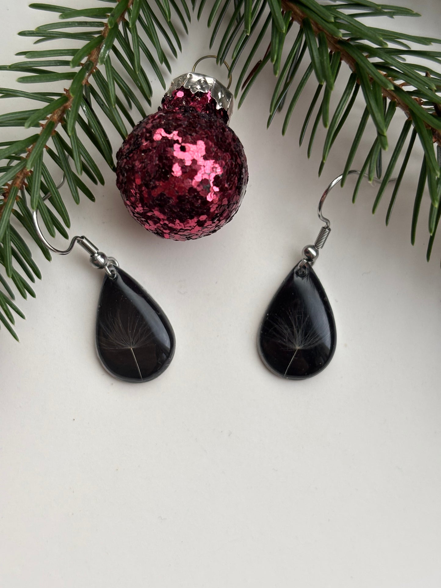 Zwevende Wens - Zwarte Oorbellen met een Paardenbloempluisje - Zilveren variant