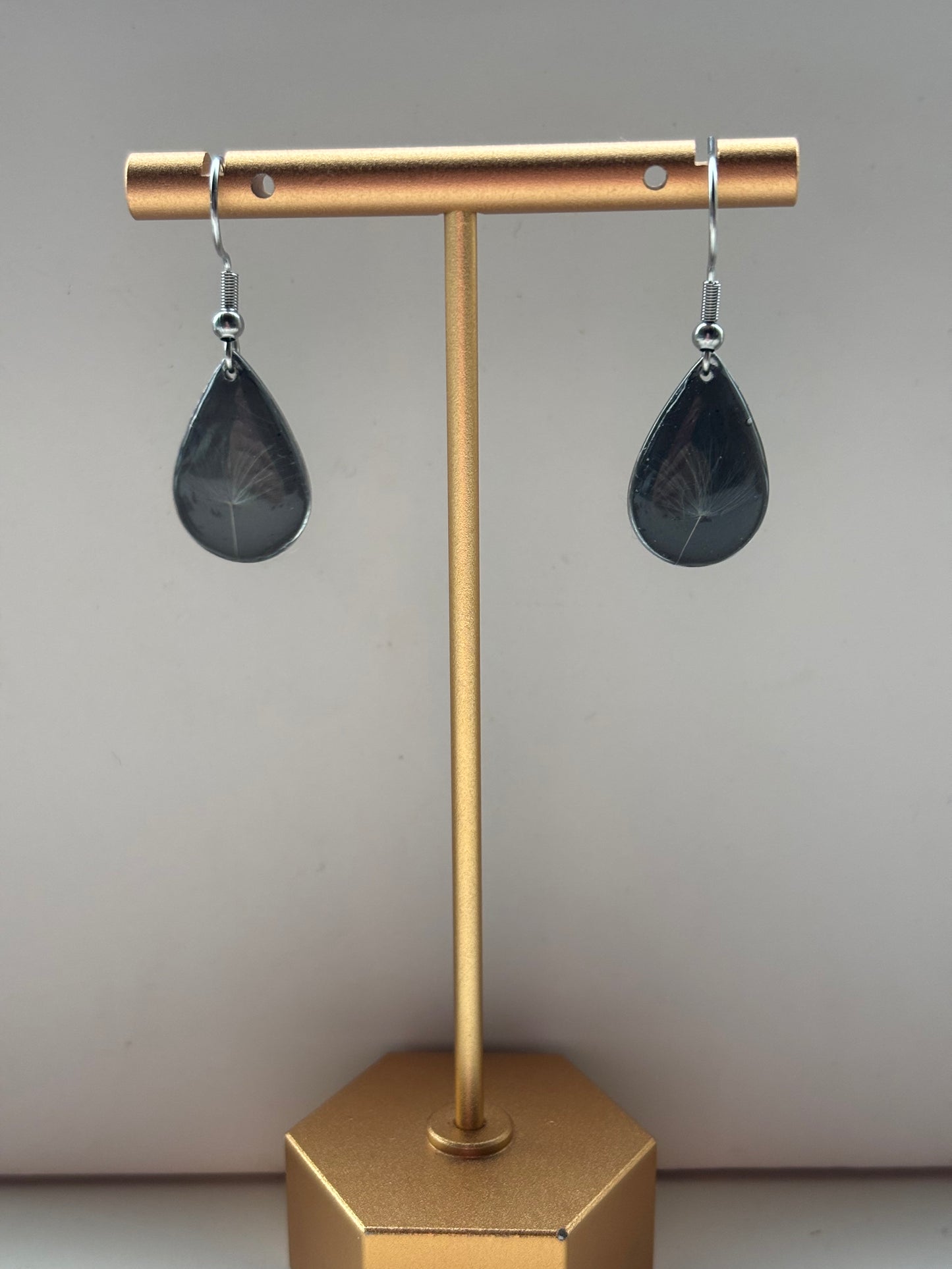 Zwevende Wens - Zwarte Oorbellen met een Paardenbloempluisje - Zilveren variant