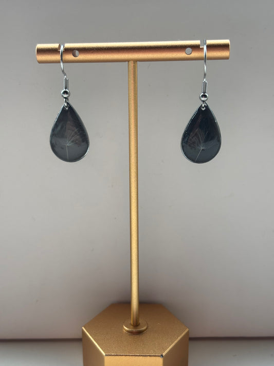 Zwevende Wens - Zwarte Oorbellen met een Paardenbloempluisje - Zilveren variant